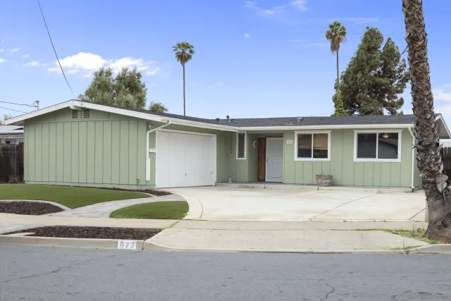 a front view of a house with a garden and yard