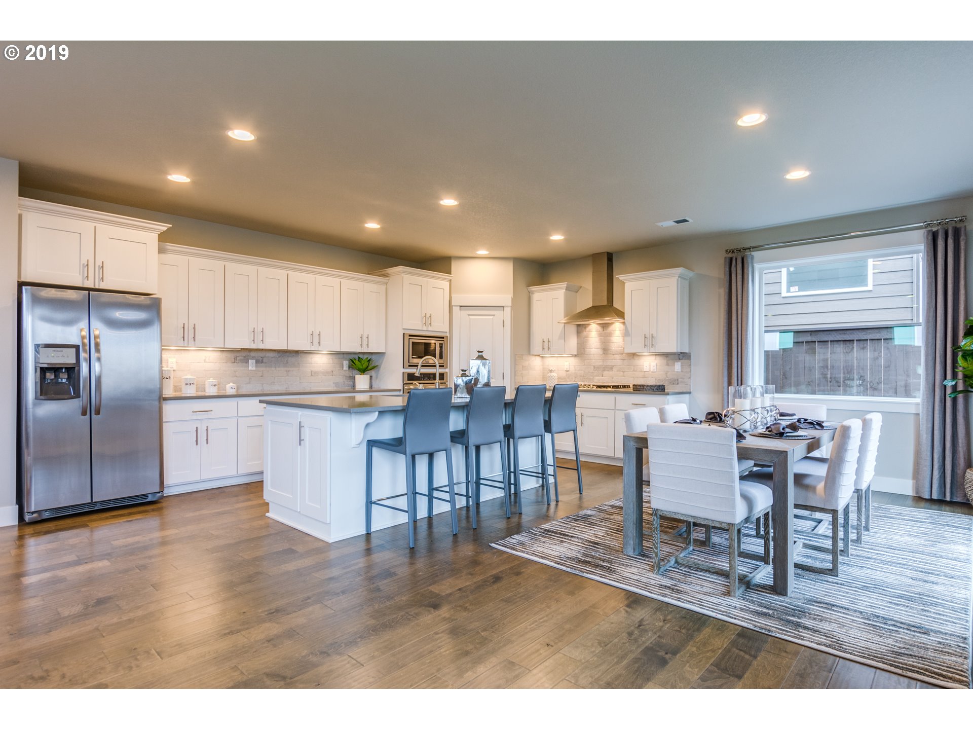 15975 Southwest Wren Lane Beaverton, OR 97007 - Photo 8 of 23 a kitchen with stainless steel appliances wooden floor dining table and chairs