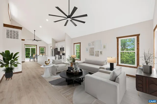 a view of a livingroom with wooden floor and a ceiling fan