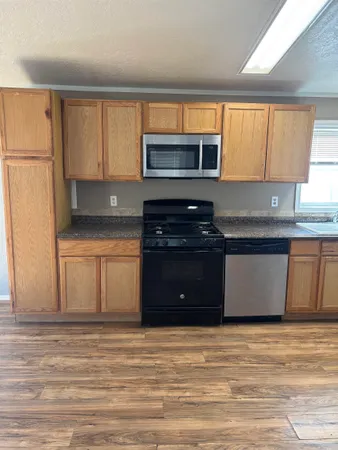 a kitchen with stainless steel appliances granite countertop a stove a sink and a refrigerator