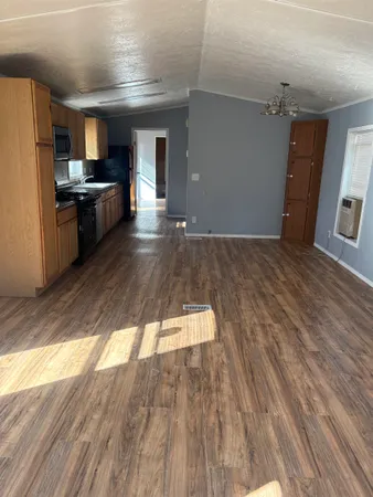 a kitchen with a sink and wooden floor