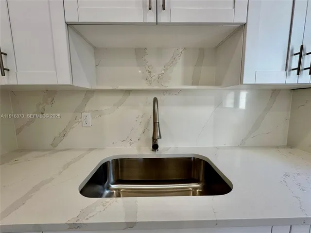 a large kitchen with a sink and cabinets