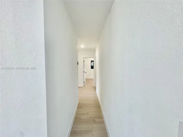 a view of a hallway with wooden floor and entryway
