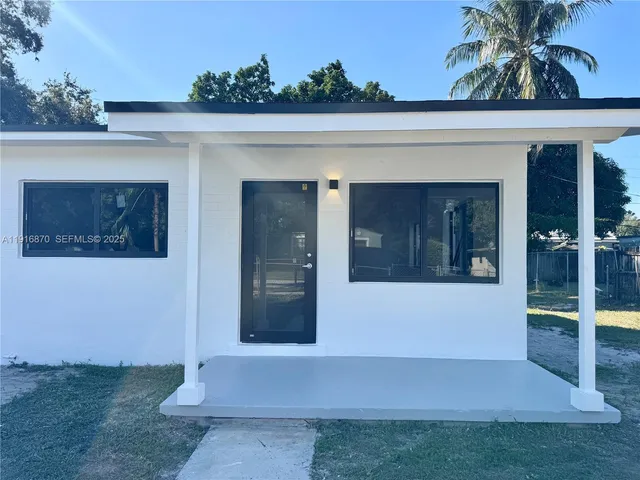 a view of a hallway with wooden floor and a living room
