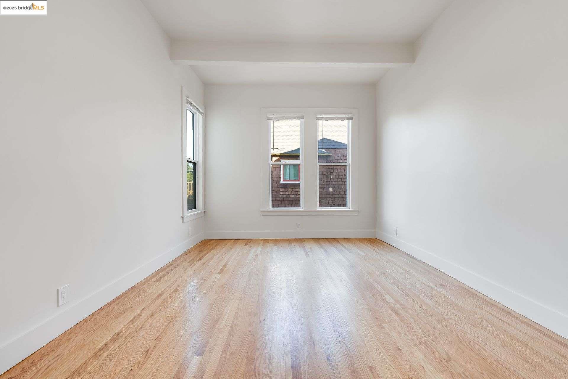 1238 12th Street Oakland, CA 94607 - Photo 12 of 55 an empty room with wooden floor and windows