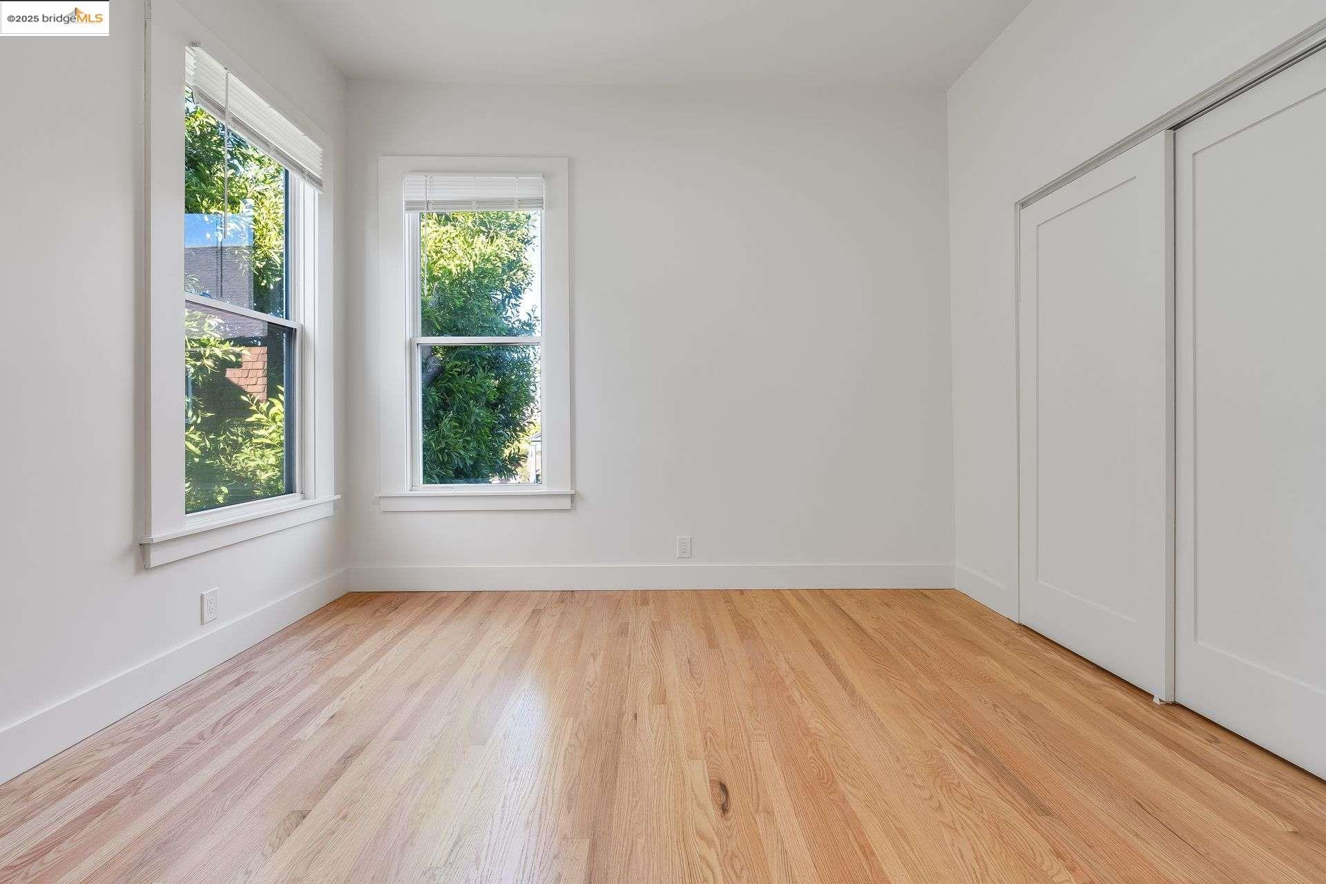 1238 12th Street Oakland, CA 94607 - Photo 16 of 55 an empty room with wooden floor and windows