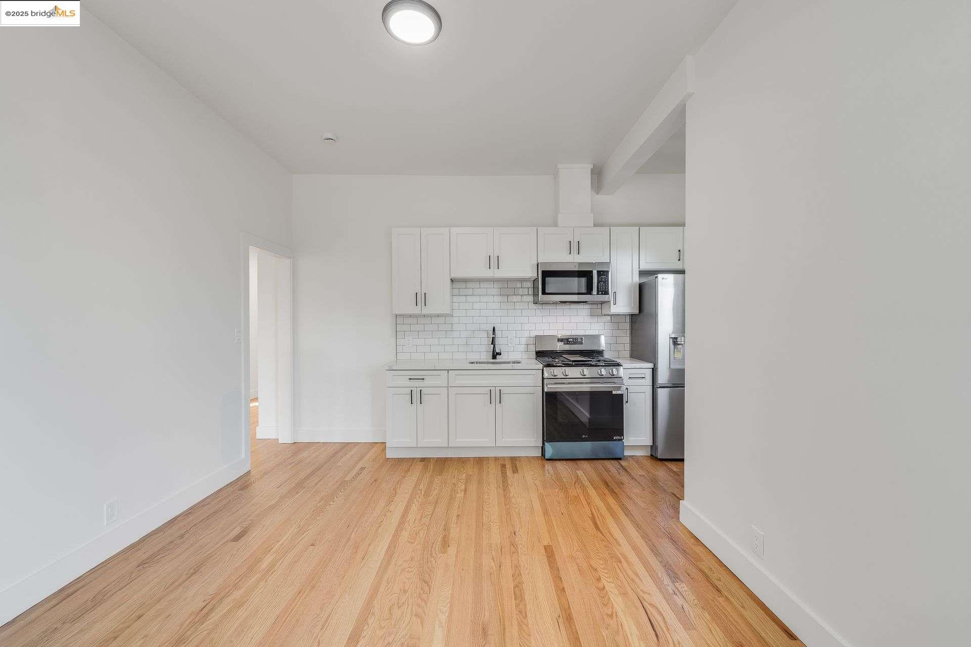 1238 12th Street Oakland, CA 94607 - Photo 19 of 55 a kitchen with stainless steel appliances granite countertop a stove and a refrigerator