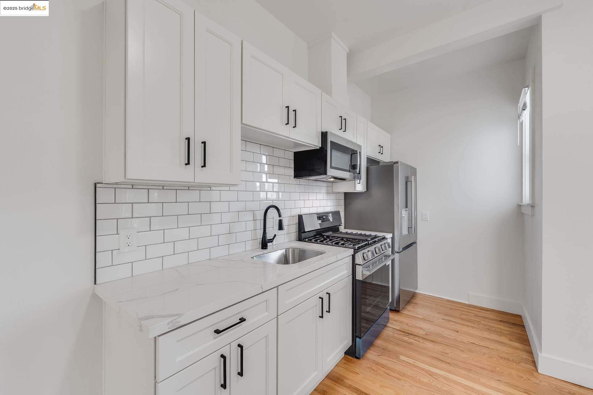 1238 12th Street Oakland, CA 94607 - Photo 20 of 55 a kitchen with stainless steel appliances a sink stove and cabinets