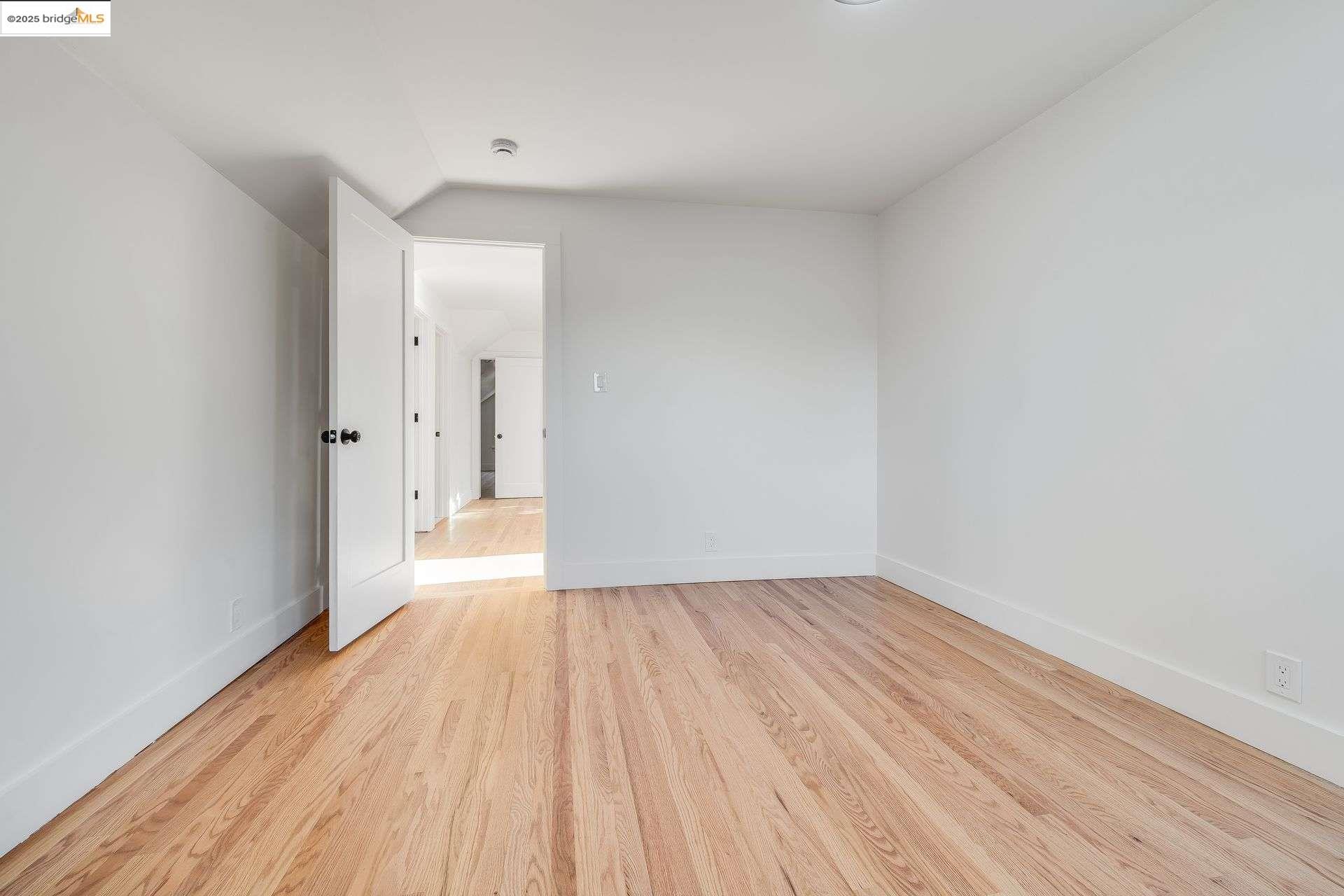 1238 12th Street Oakland, CA 94607 - Photo 27 of 55 a view of an empty room with wooden floor and a window
