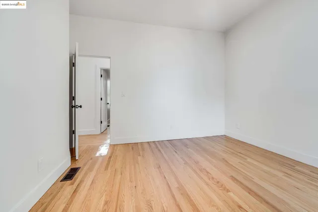 a view of room with wooden floor and white walls