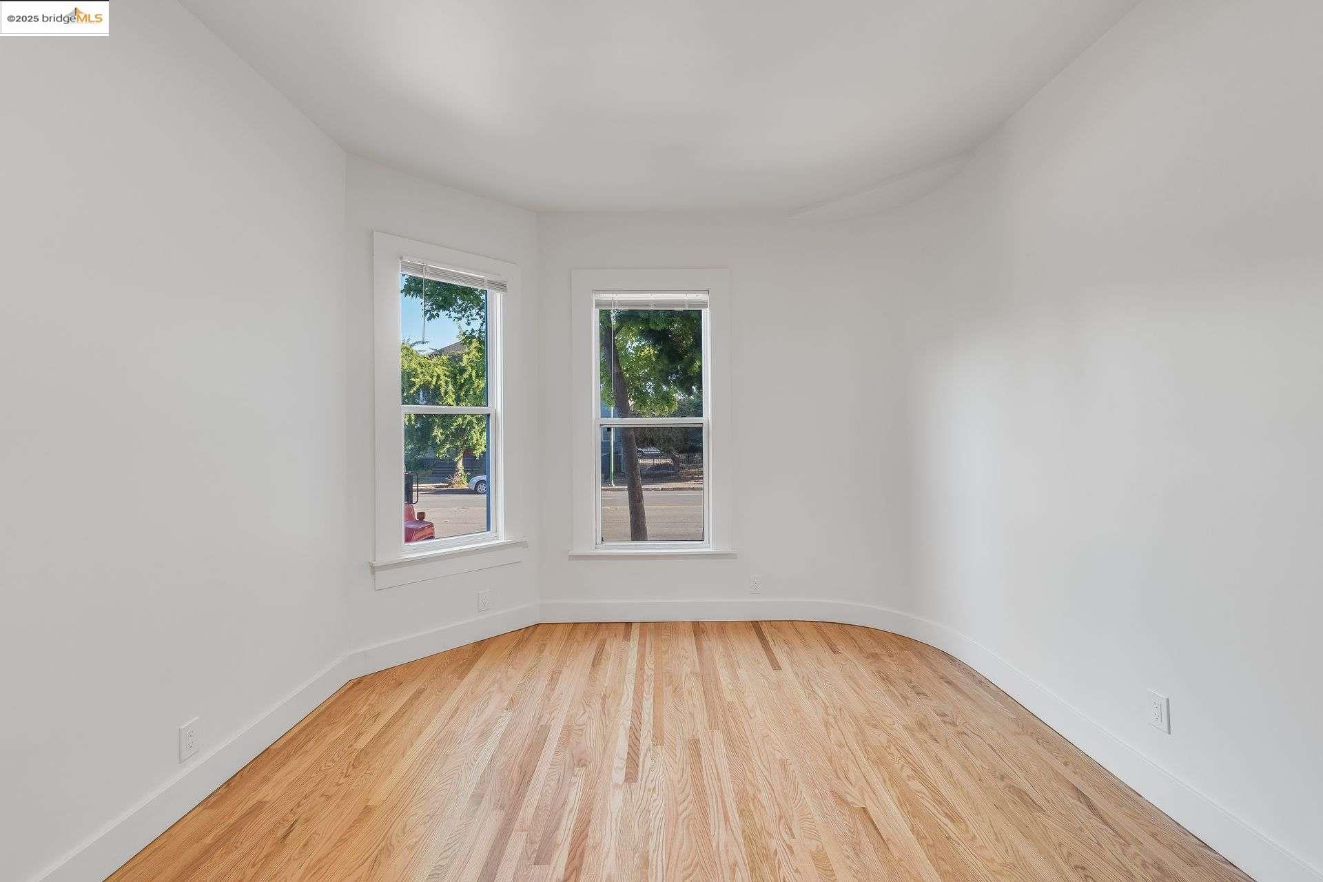 1238 12th Street Oakland, CA 94607 - Photo 47 of 55 an empty room with wooden floor and windows