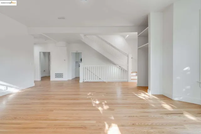 a view of a livingroom with wooden floor and staircase