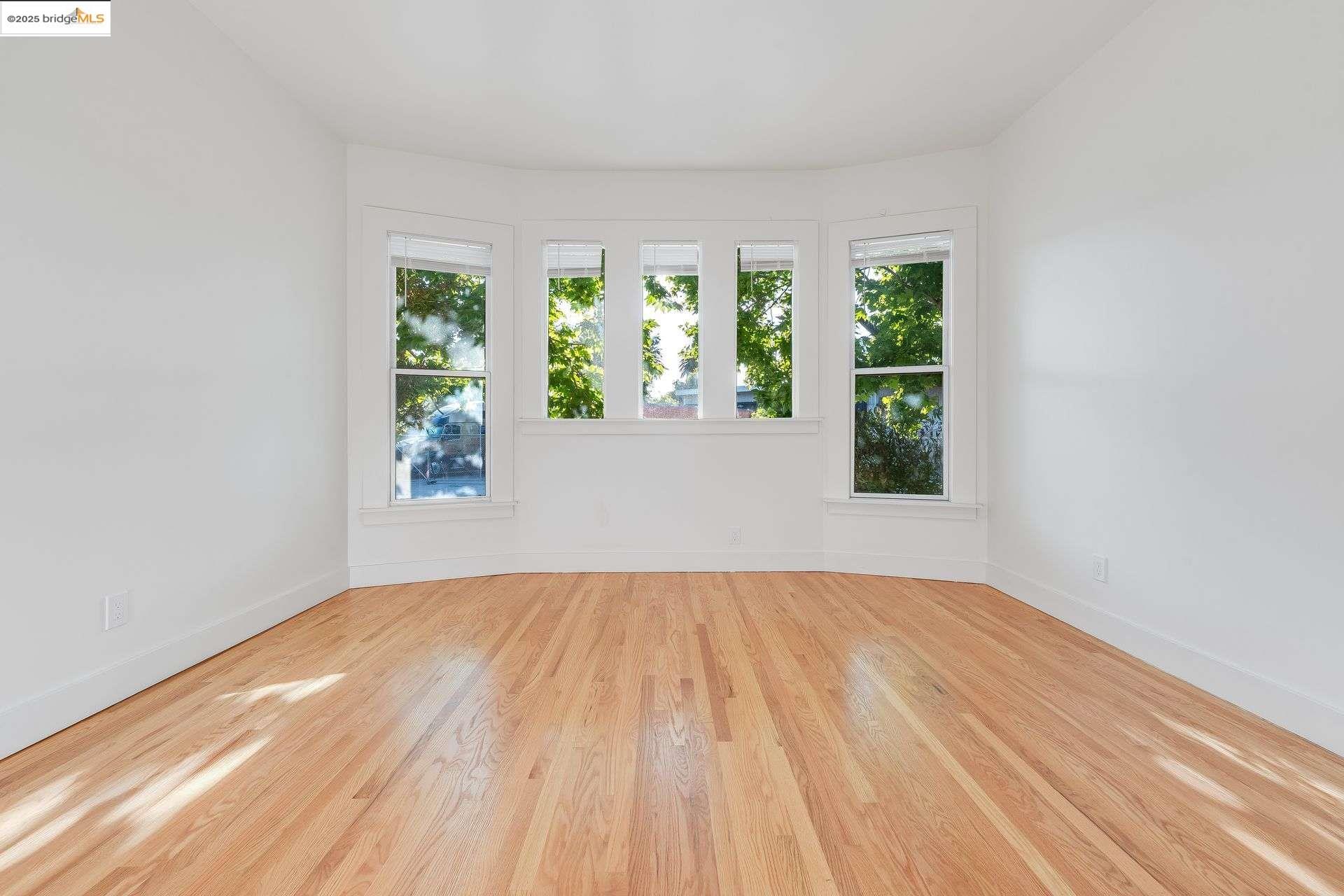 1238 12th Street Oakland, CA 94607 - Photo 51 of 55 a view of an empty room with wooden floor and a window