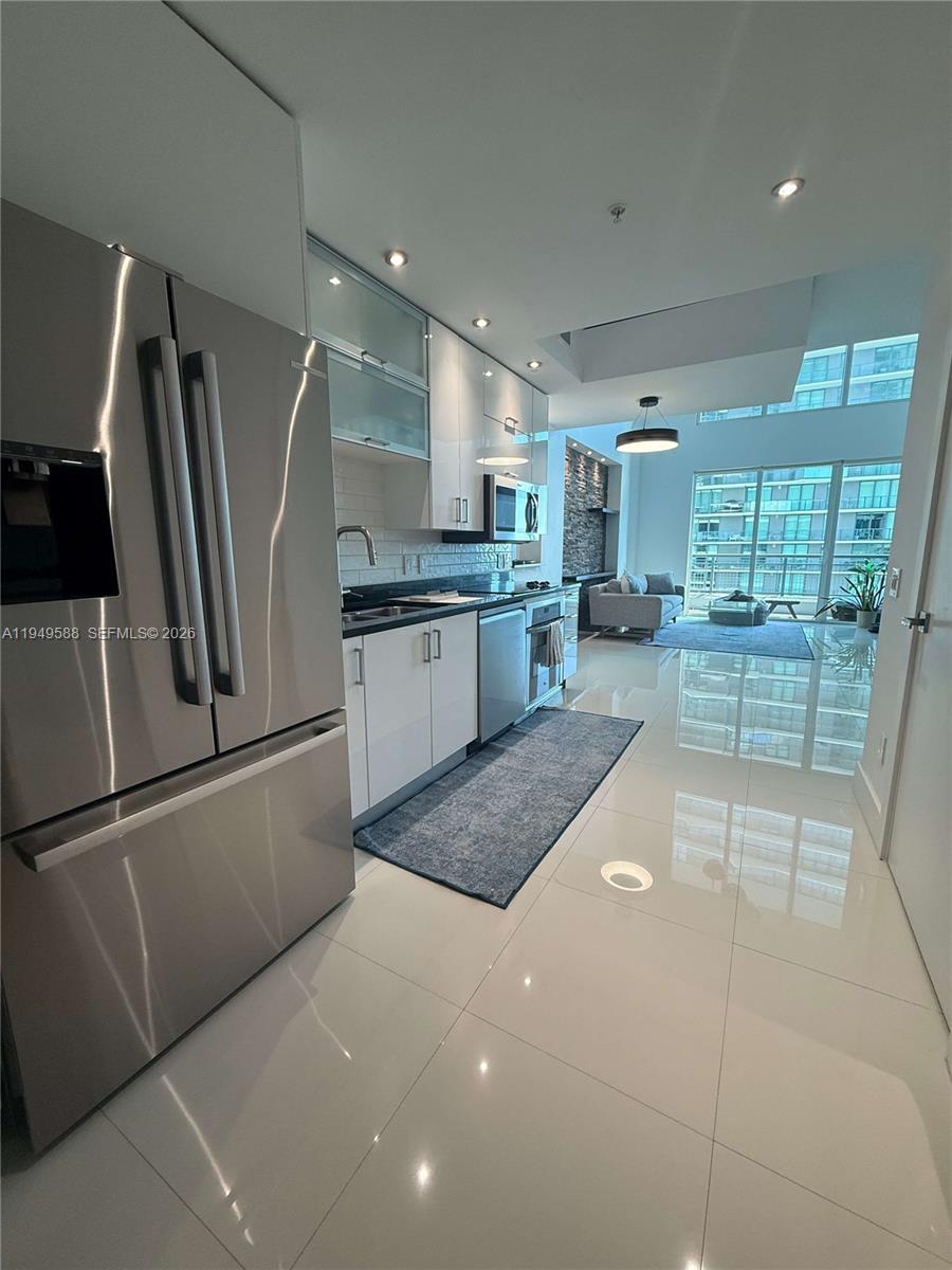 a large kitchen with a large counter top appliances and cabinets