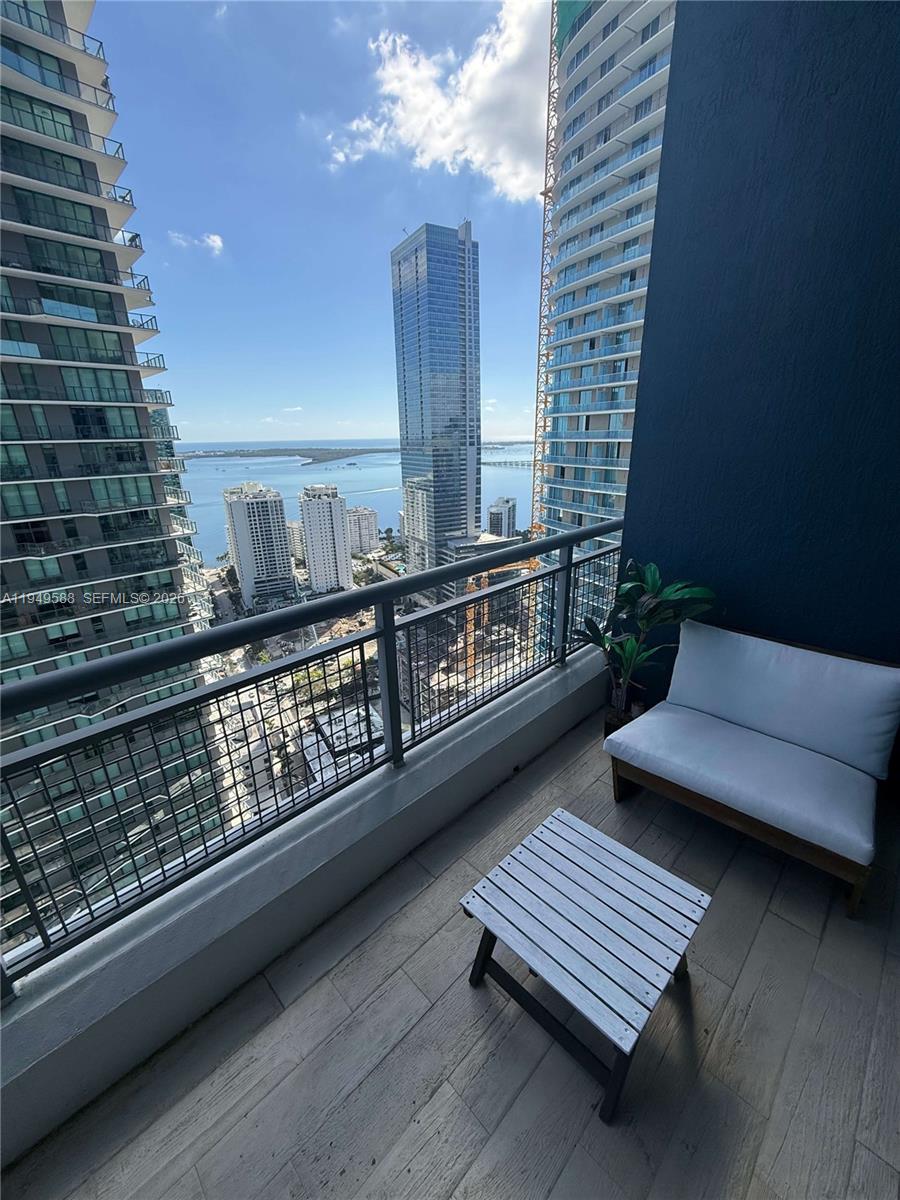 60 Southwest 13th Street, Unit 3808 Miami, FL 33130 - Photo 16 of 38 a view of a balcony with wooden floor and outdoor seating