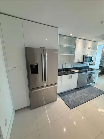 a kitchen with stainless steel appliances granite countertop a refrigerator and a sink