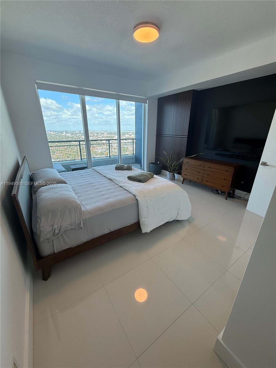 60 Southwest 13th Street, Unit 3808 Miami, FL 33130 - Photo 32 of 38 a bedroom with a bed and a large window