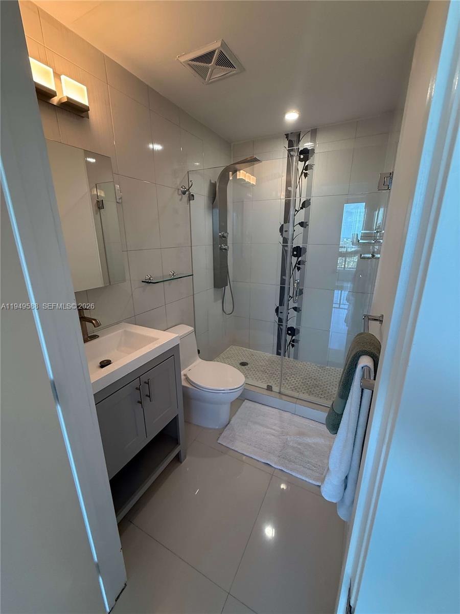 60 Southwest 13th Street, Unit 3808 Miami, FL 33130 - Photo 35 of 38 a bathroom with a sink a toilet and a shower