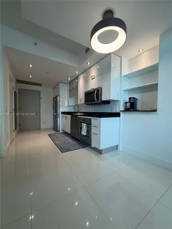 a large kitchen with stainless steel appliances granite countertop a sink and a stove