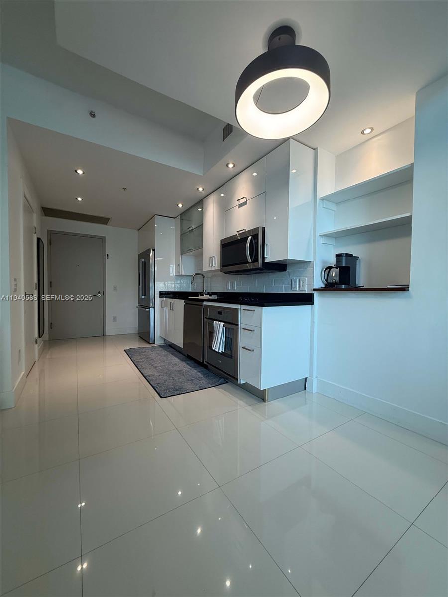 60 Southwest 13th Street, Unit 3808 Miami, FL 33130 - Photo 5 of 38 a large kitchen with stainless steel appliances granite countertop a sink and a stove