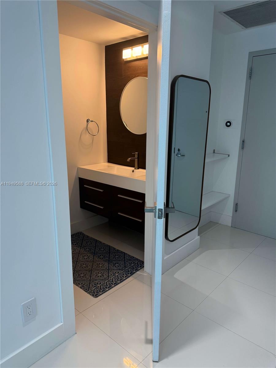 60 Southwest 13th Street, Unit 3808 Miami, FL 33130 - Photo 8 of 38 a bathroom with a sink and mirror
