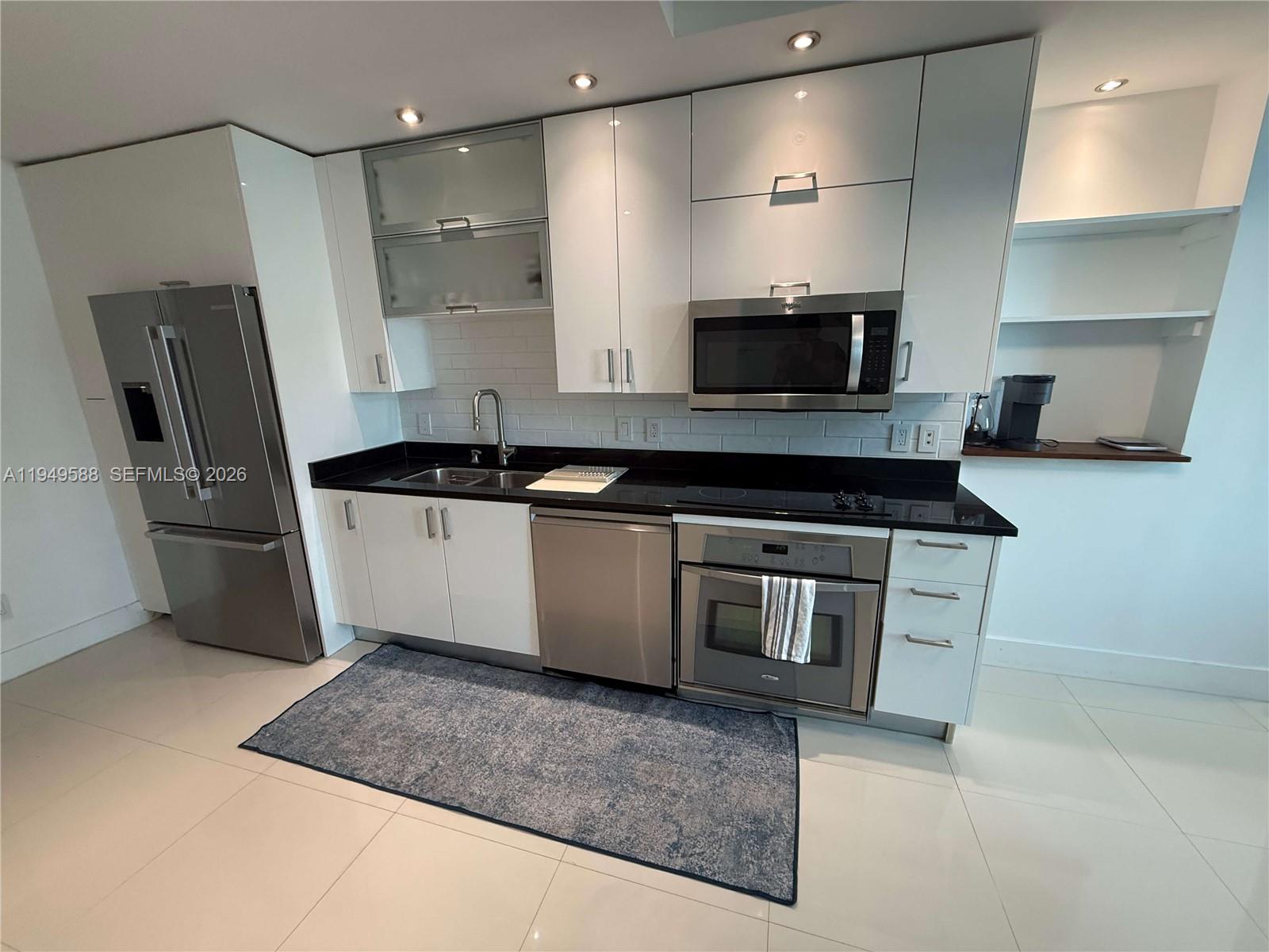 60 Southwest 13th Street, Unit 3808 Miami, FL 33130 - Photo 10 of 38 a kitchen with stainless steel appliances granite countertop a sink and a stove