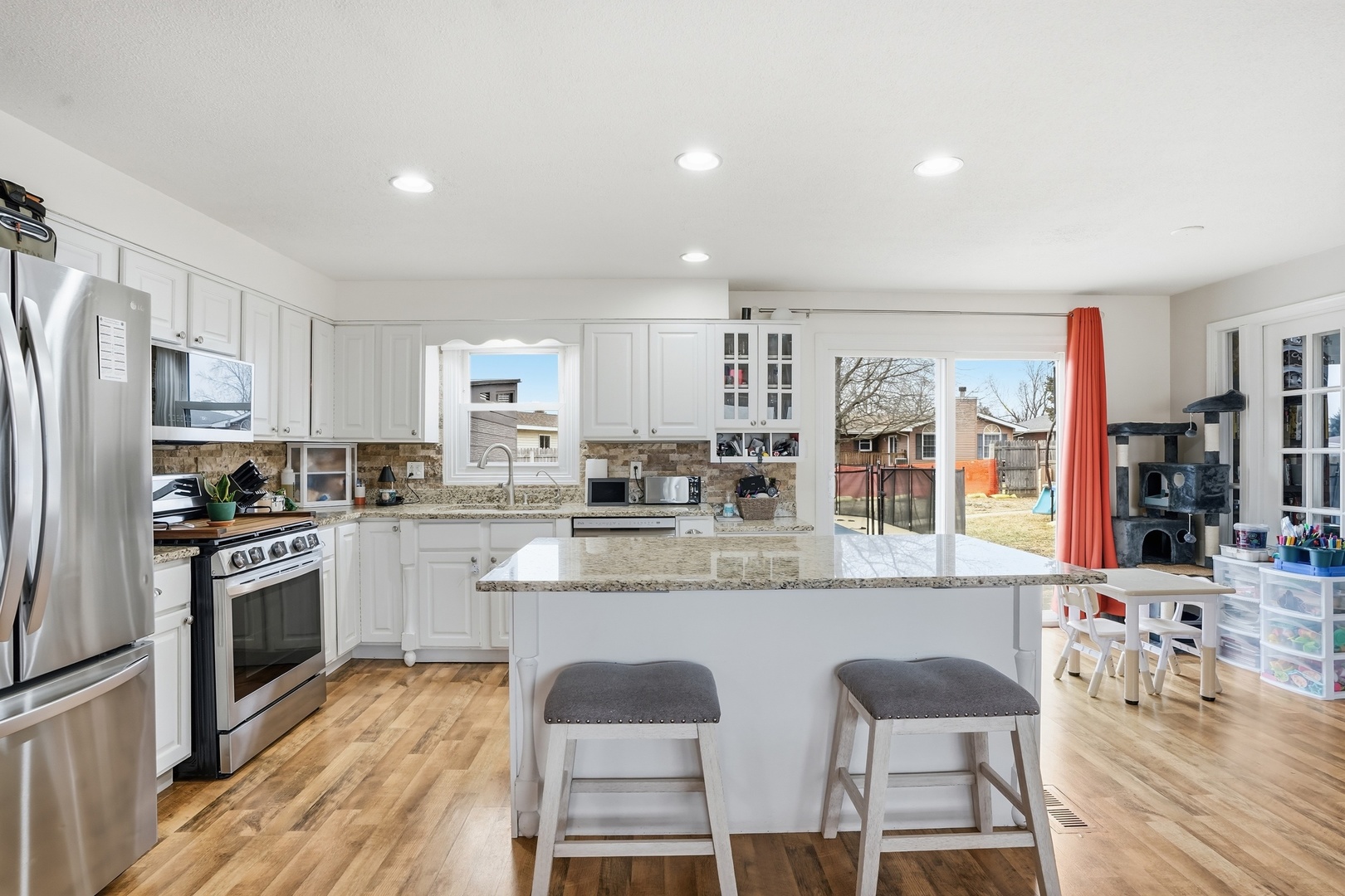 385 South Walnut Street Manteno, IL 60950 - Photo 5 of 27 a kitchen with stainless steel appliances granite countertop a stove top oven a refrigerator a sink and a dining table with wooden floor