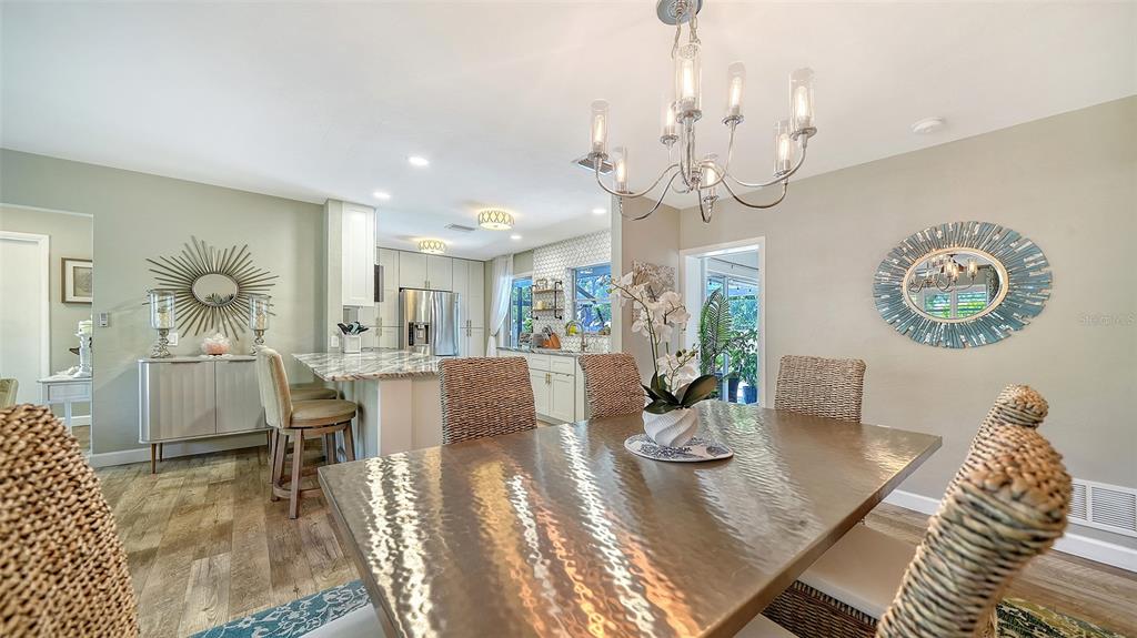 6758 South Lockwood Ridge Road Sarasota, FL 34231 - Photo 13 of 85 a view of a dining room with furniture a chandelier and wooden floor