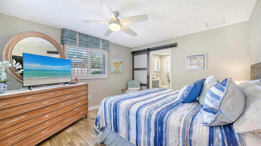 6758 South Lockwood Ridge Road Sarasota, FL 34231 - Photo 32 of 85 a bedroom with a bed and a flat screen tv