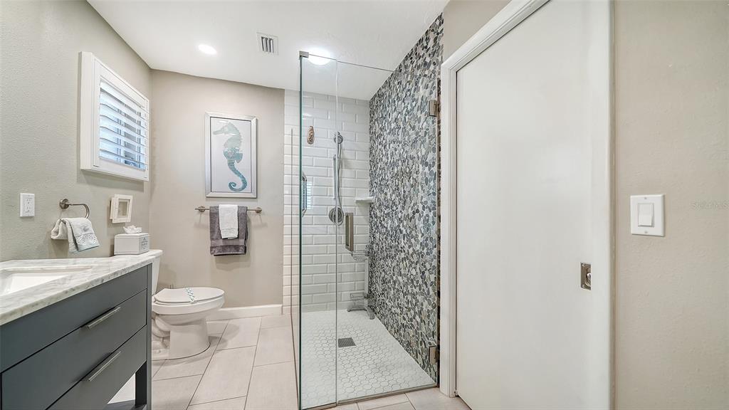 6758 South Lockwood Ridge Road Sarasota, FL 34231 - Photo 35 of 85 a bathroom with a shower a sink a toilet and a mirror