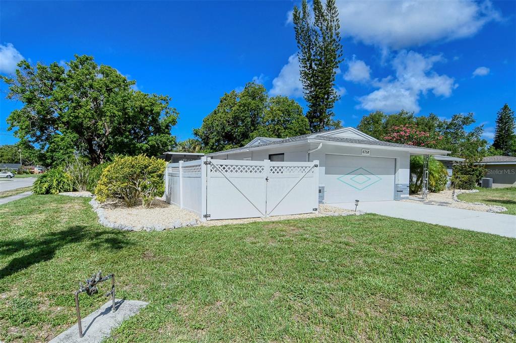 6758 South Lockwood Ridge Road Sarasota, FL 34231 - Photo 47 of 85 a white house that has a tree in front of it