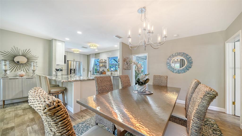 6758 South Lockwood Ridge Road Sarasota, FL 34231 - Photo 10 of 85 a view of a dining room with furniture a chandelier and wooden floor