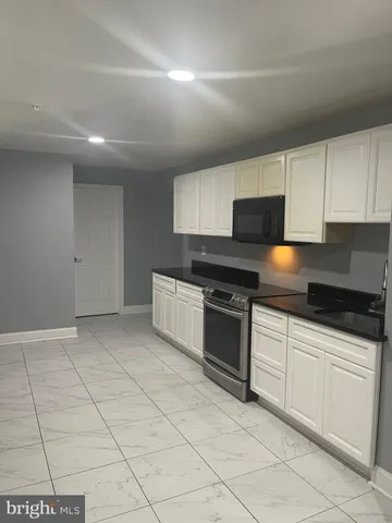 a kitchen with granite countertop a stove sink and cabinets