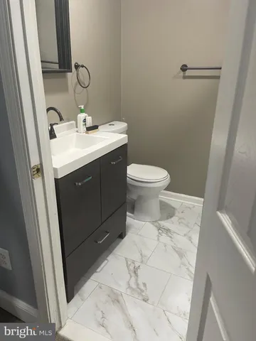 a bathroom with a sink vanity and toilet