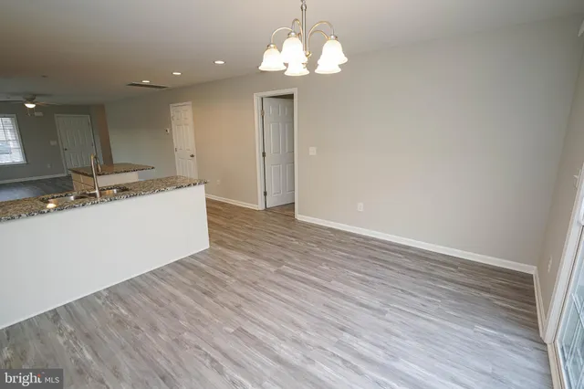 a spacious bathroom with a granite countertop sink toilet a mirror and vanity