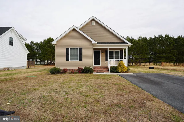 a front view of house with yard and trees around