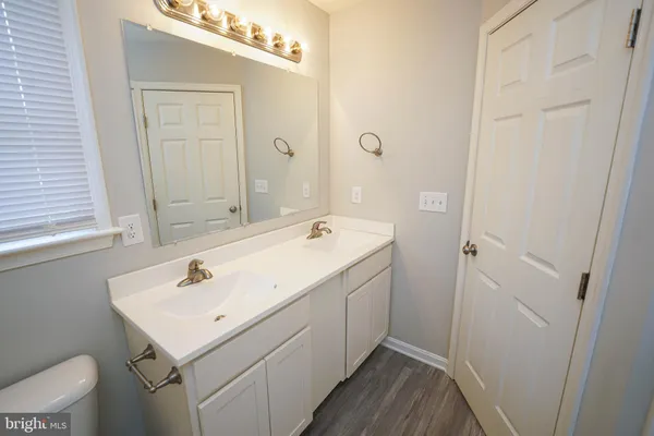 a bathroom with a sink and mirror with toilet
