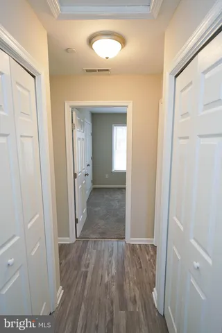a view of a hallway with wooden floor