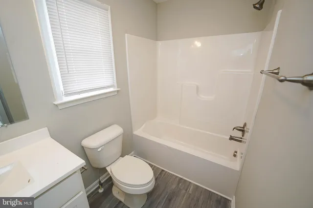 a white toilet sitting next to a bath tub