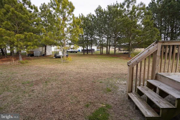 a view of a house with backyard and trees