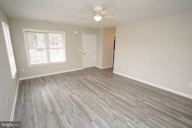 wooden floor in an empty room with a window