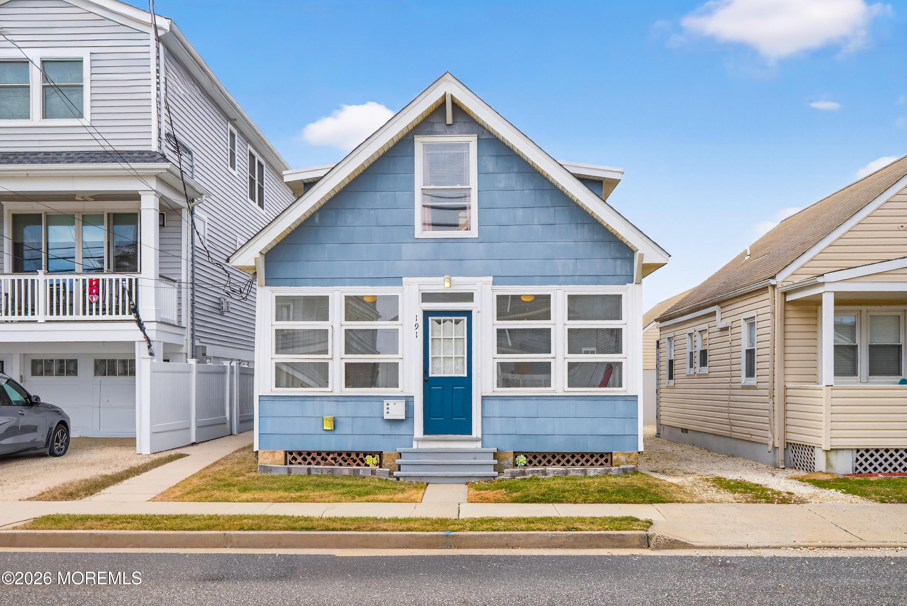 a view of house that has a small yard and wooden fence