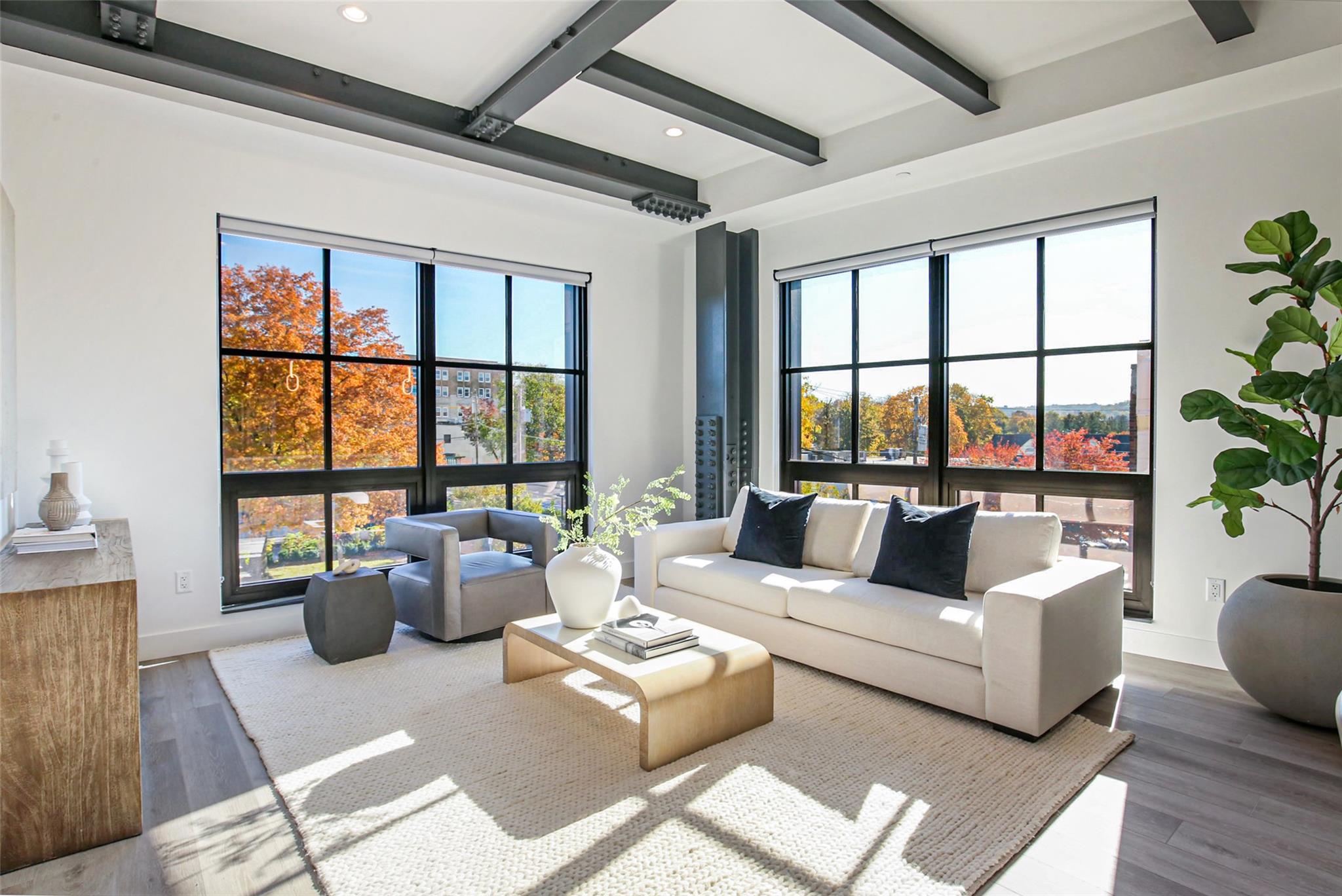 a living room with furniture and floor to ceiling windows