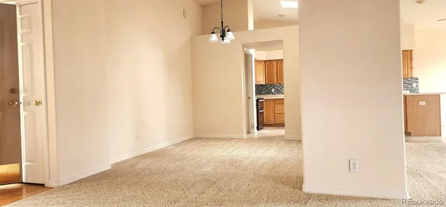 a view of a hallway with wooden floor and a bathroom