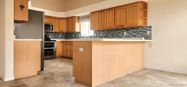a view of kitchen with wooden cabinets