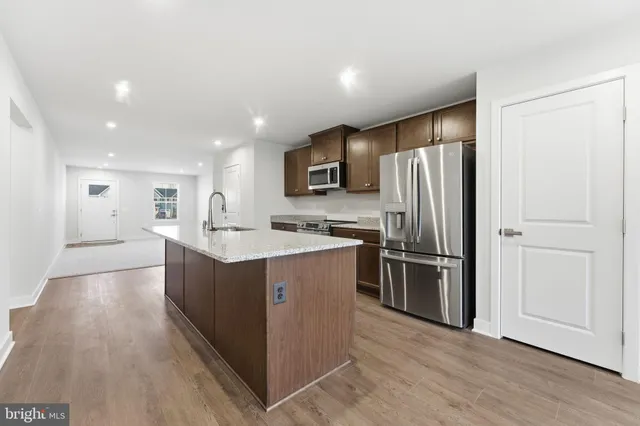 a kitchen with stainless steel appliances granite countertop a sink stove and cabinets