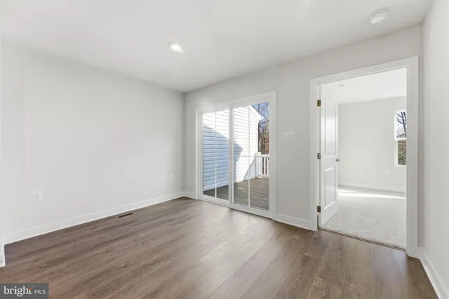 a view of a livingroom with wooden floor and a ceiling fan