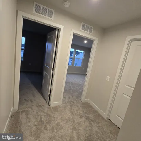 a view of a hallway with wooden floor and a hallway