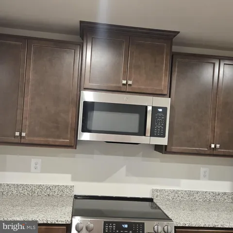 a kitchen with a refrigerator stove and cabinets