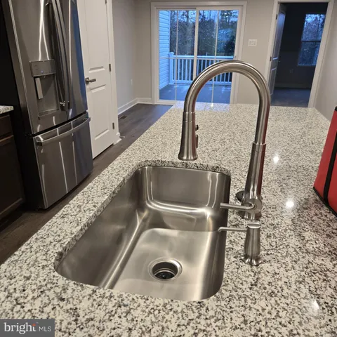 a kitchen with kitchen island a sink stove and refrigerator